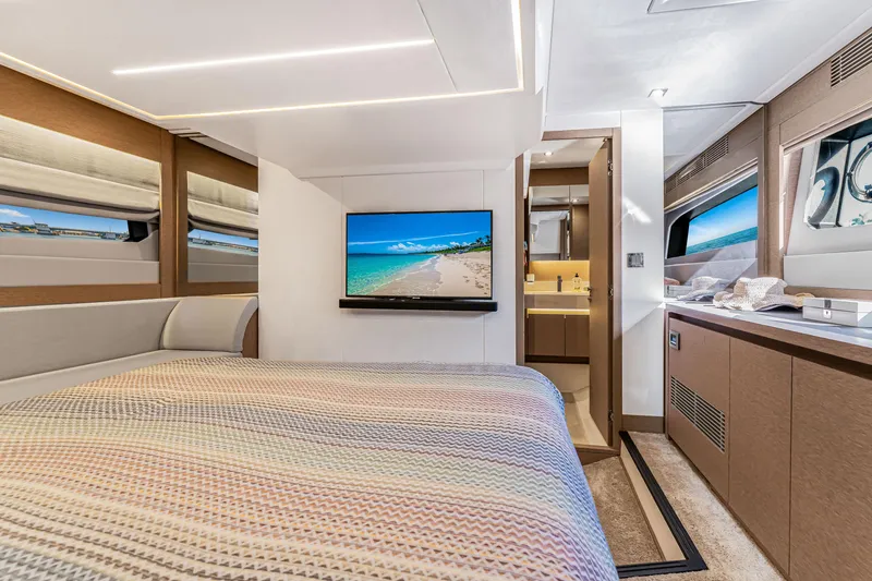 Slide: The Image of Luxurious 2018 Prestige 520 yacht bedroom with TV, modern decor, and ocean view windows. - 38