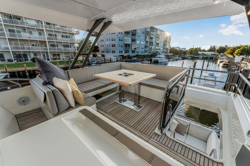 Slide: The Image of Luxurious 2018 Prestige 520 yacht deck with seating, table, and waterfront view. - 52