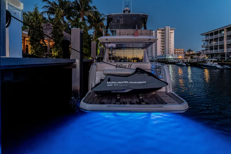 Slide: The Image of Luxury 2018 Prestige 520 yacht docked at sunset with glowing underwater lights. - 66