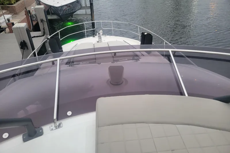 Slide: The Image of Luxury Prestige 520 yacht with Yamaha jet ski, docked in scenic waterfront setting. - 8