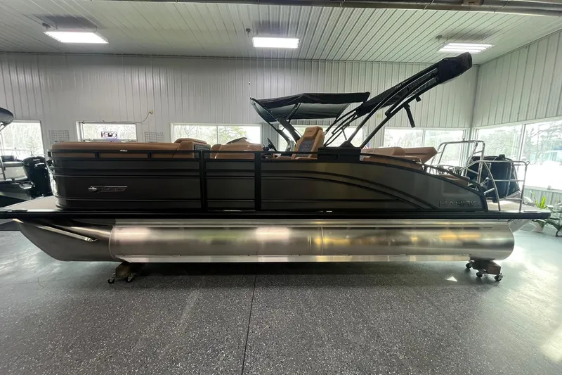 The Image of 2025 Harris Solstice 230 pontoon boat in showroom, featuring sleek design and modern amenities. - 1