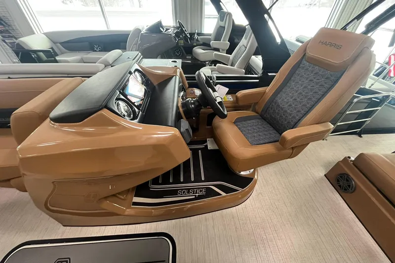 Slide: The Image of 2025 Harris Solstice 230 boat interior with luxurious captain's chair and modern dashboard. - 10