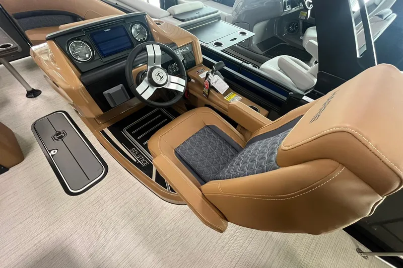 Slide: The Image of 2025 Harris Solstice 230 boat interior with tan leather seating and modern dashboard. - 18