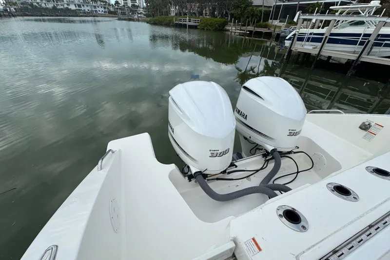 Slide: The Image of 2020 Pursuit S 328 Sport boat with twin Yamaha 300 engines docked by the water. - 15