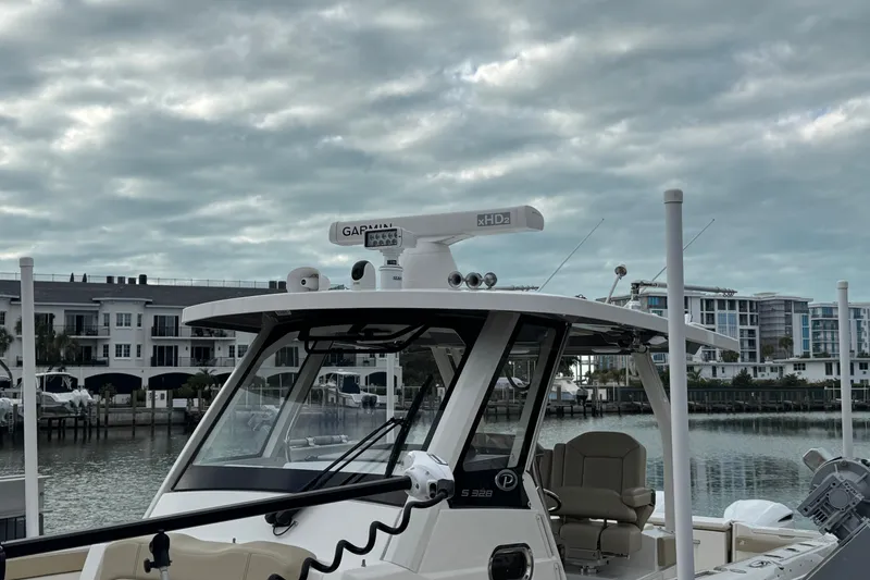 Slide: The Image of 2020 Pursuit S 328 Sport boat docked near waterfront buildings under cloudy sky. - 18