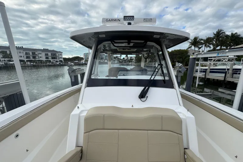 Slide: The Image of 2020 Pursuit S 328 Sport boat docked, featuring a sleek design and modern navigation equipment. - 28
