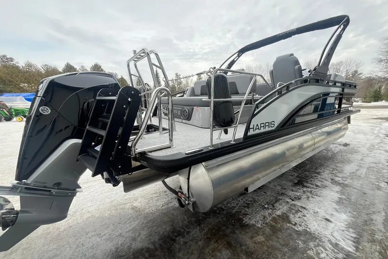 Slide: The Image of 2025 Harris Solstice 230 pontoon boat with sleek design and powerful outboard motor. - 4