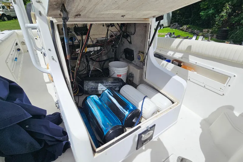 Slide: The Image of Open storage compartment on 1993 Marlin 350 Sportfish boat, showing equipment and wiring. - 26