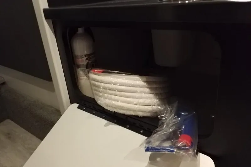 Slide: The Image of Storage compartment in a 2019 Formula 382 FASTech boat with safety equipment and supplies. - 16