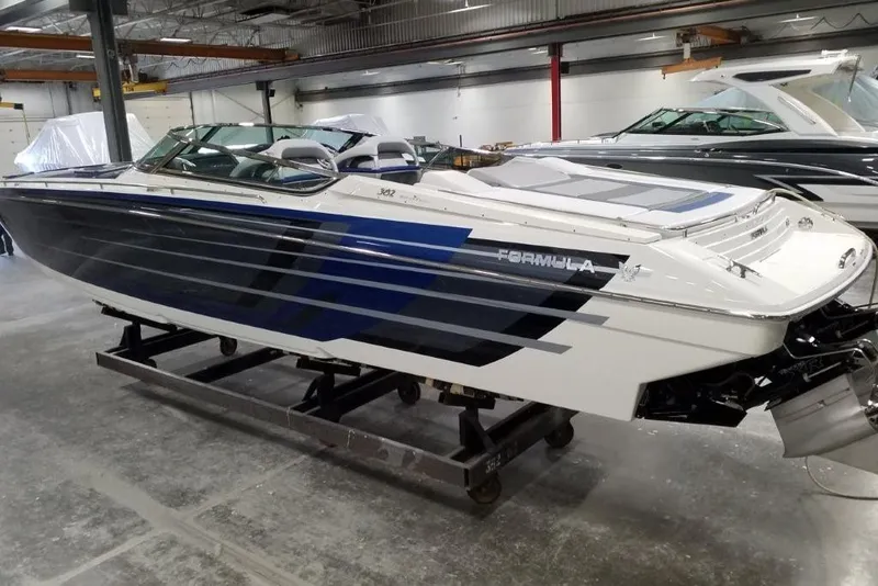 Slide: The Image of 2019 Formula 382 FASTech speedboat in showroom, sleek design with blue and white accents. - 3