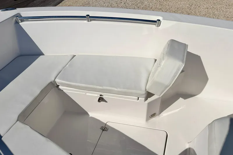 Slide: The Image of 2023 Aquasport 2200 Center Console boat seating area with white cushions. - 12