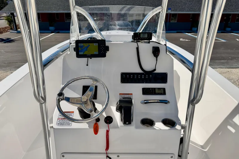 Slide: The Image of 2023 Aquasport 2200 Center Console boat dashboard with steering wheel and navigation equipment. - 18