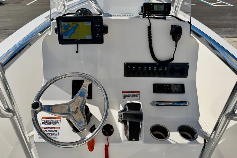 Slide: The Image of 2023 Aquasport 2200 Center Console dashboard with steering wheel and navigation equipment. - 19