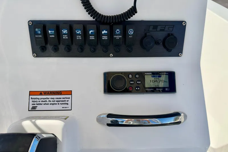 Slide: The Image of Control panel of 2023 Aquasport 2200 Center Console with switches and warning label. - 22