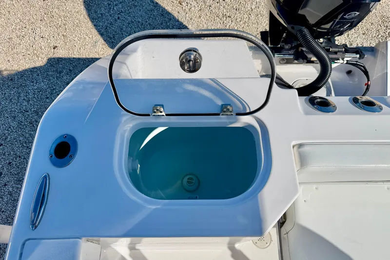Slide: The Image of 2023 Aquasport 2200 Center Console boat with open livewell and rod holders. - 26