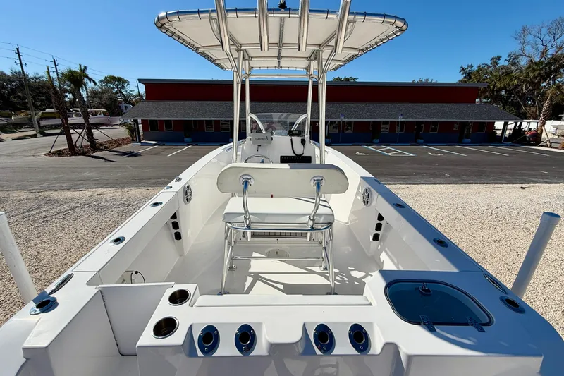 Slide: The Image of 2023 Aquasport 2200 Center Console boat with T-top and seating, parked outdoors. - 27