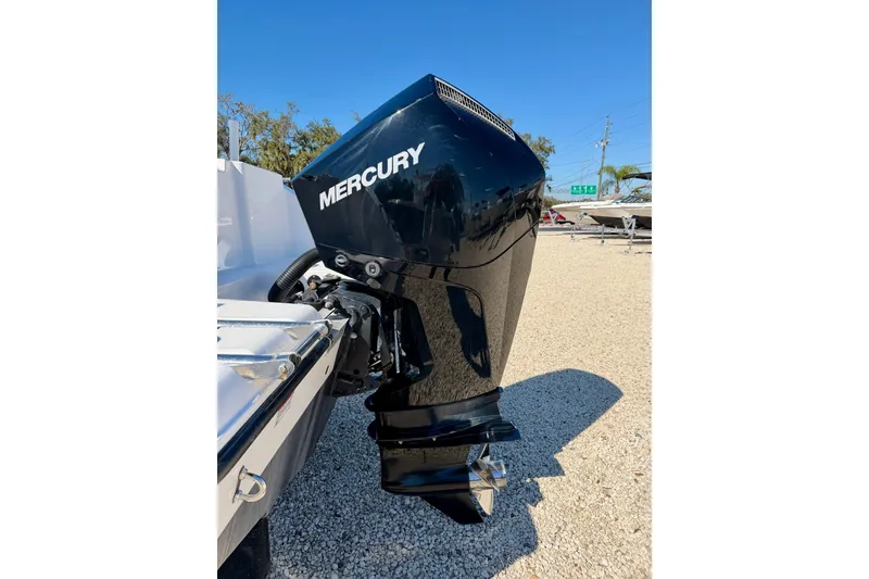Slide: The Image of 2023 Aquasport 2200 Center Console with Mercury outboard engine, parked on gravel. - 29
