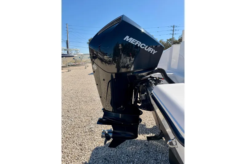 Slide: The Image of 2023 Aquasport 2200 Center Console with Mercury outboard engine, displayed outdoors. - 31