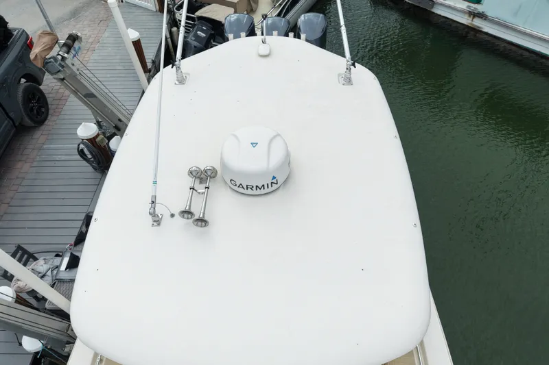 Slide: The Image of 2015 Cobia 344 Center Console boat with Garmin equipment, docked by the water. - 12