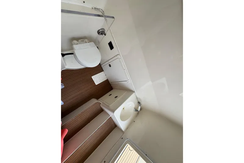 Slide: The Image of 2015 Cobia 344 Center Console boat interior with toilet and sink. - 16