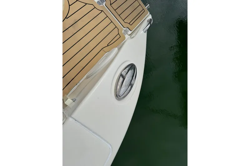 Slide: The Image of 2015 Cobia 344 Center Console boat deck with wood finish and water reflection. - 17