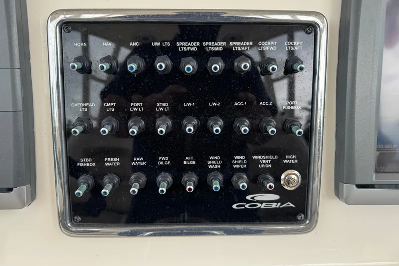 Slide: The Image of Control panel of a 2015 Cobia 344 Center Console boat with labeled switches. - 30