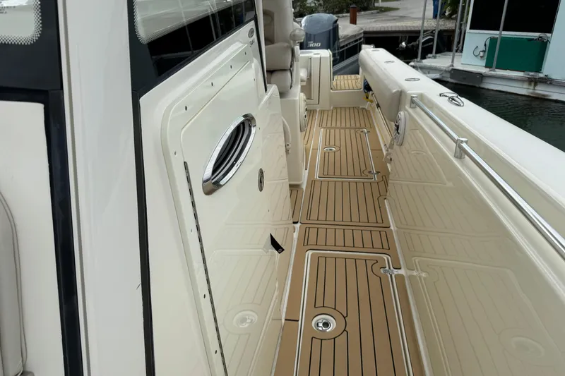 Slide: The Image of 2015 Cobia 344 Center Console boat with teak-style deck, docked at marina. - 40