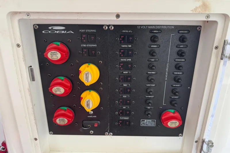Slide: The Image of Control panel of a 2015 Cobia 344 Center Console boat, featuring switches and circuit breakers. - 55