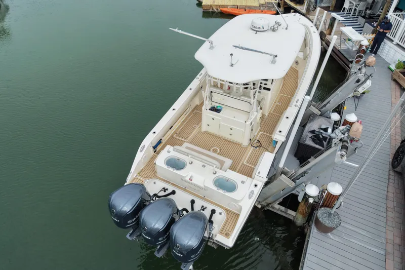 Slide: The Image of 2015 Cobia 344 Center Console boat docked with triple Yamaha outboard engines. - 6