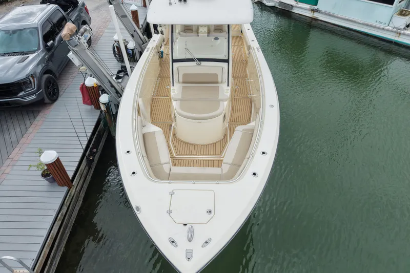 Slide: The Image of 2015 Cobia 344 Center Console boat docked, aerial view showing spacious deck and seating. - 7
