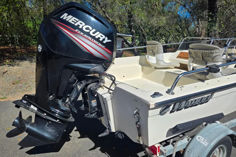 Slide: The Image of 1989 Wahoo 16.2 boat with Mercury FourStroke engine on trailer in wooded area. - 18