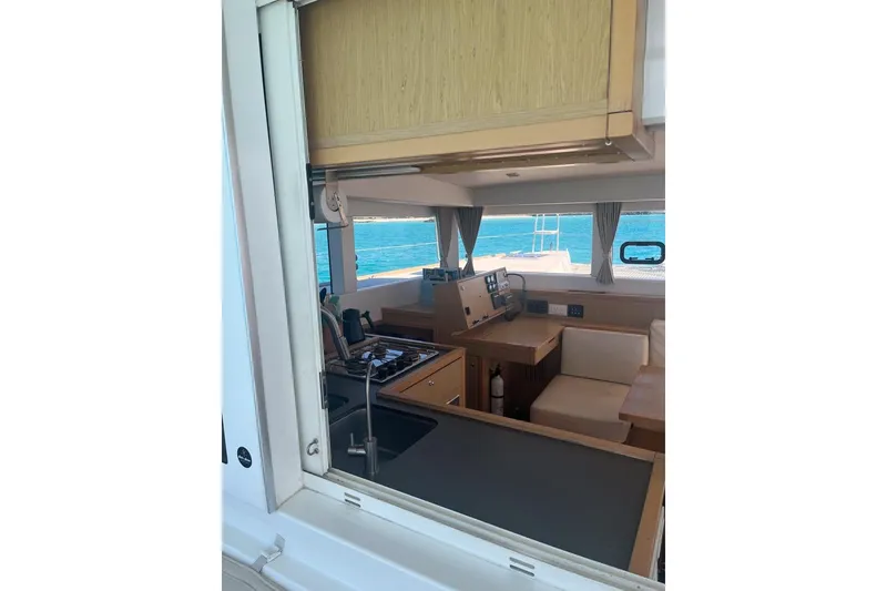 Slide: The Image of Interior view of 2014 Lagoon 39 catamaran, featuring kitchen and seating area with ocean backdrop. - 15