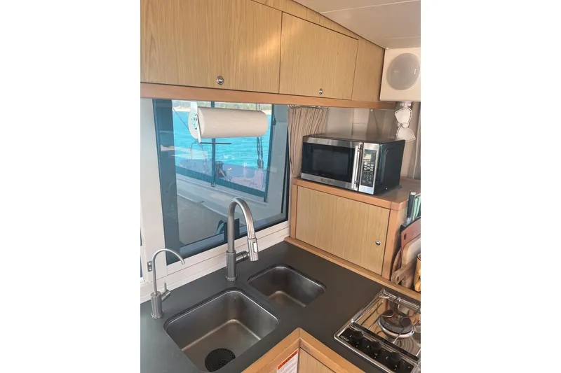 Slide: The Image of Interior of 2014 Lagoon 39 yacht kitchen with sink, microwave, and window view. - 18