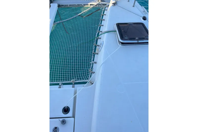 Slide: The Image of 2014 Lagoon 39 catamaran deck with netting and hatch, sailing on blue water. - 9