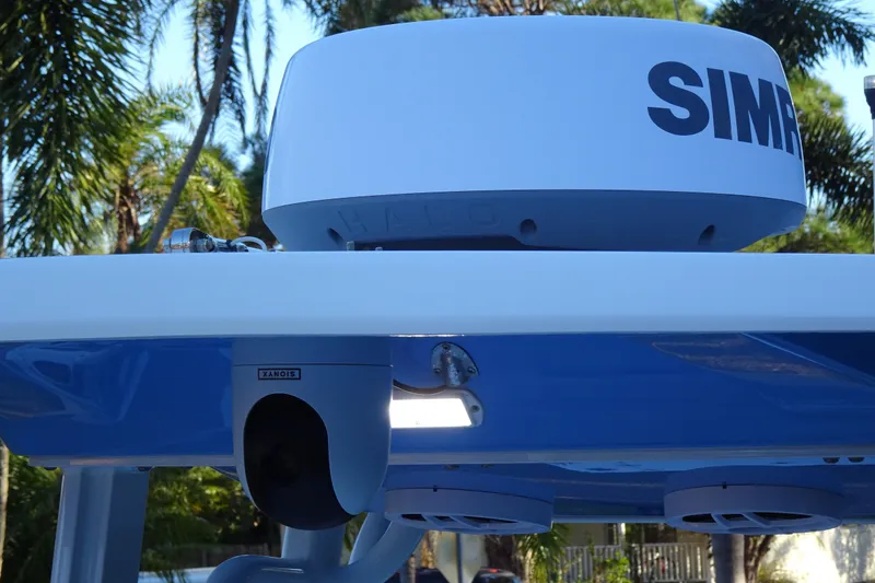Slide: The Image of 2022 Robalo 246 Cayman boat with Simrad radar and camera, surrounded by palm trees. - 12