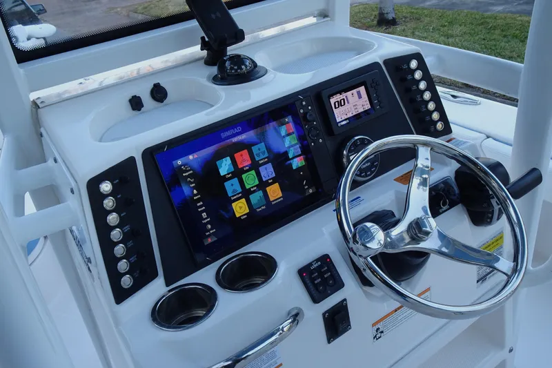 Slide: The Image of 2022 Robalo 246 Cayman boat dashboard with steering wheel and electronic controls. - 15