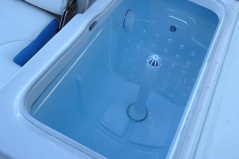 Slide: The Image of Livewell on 2022 Robalo 246 Cayman boat, featuring a clean, blue interior. - 19