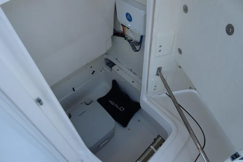 Slide: The Image of 2022 Robalo 246 Cayman boat storage compartment with equipment and wiring. - 22