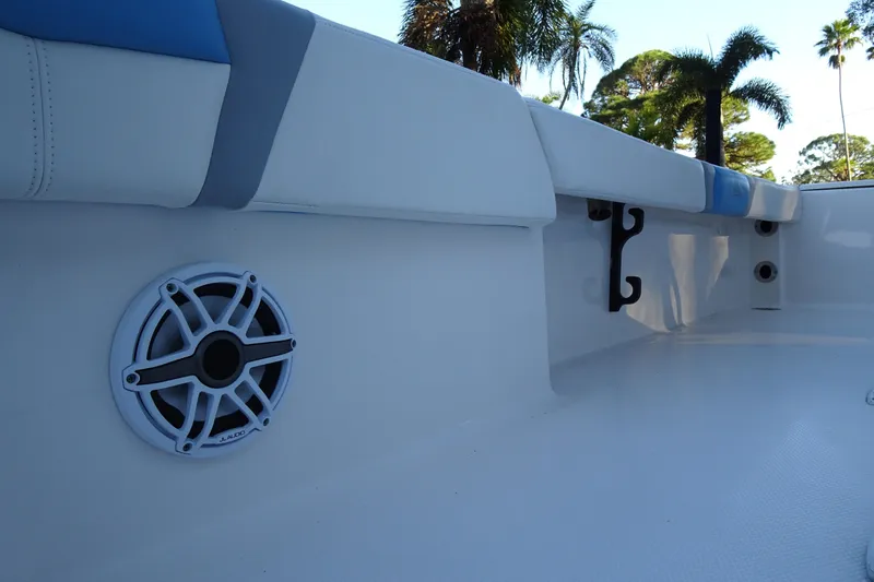 Slide: The Image of 2022 Robalo 246 Cayman boat interior with speaker and cushioned seating. - 27