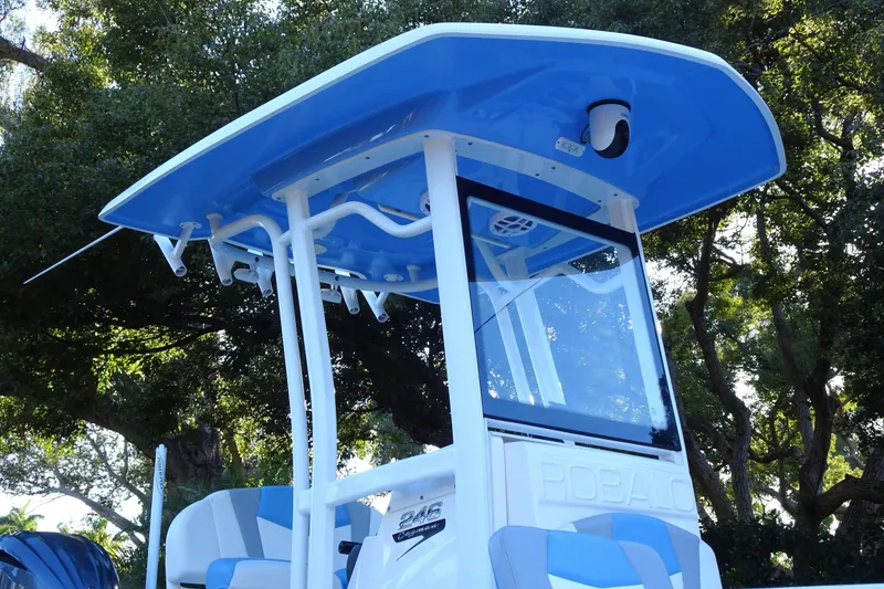 Slide: The Image of 2022 Robalo 246 Cayman boat with blue T-top, surrounded by trees. - 8