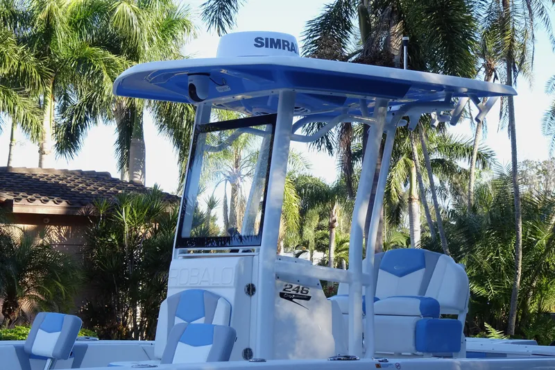Slide: The Image of 2022 Robalo 246 Cayman boat with blue accents, surrounded by palm trees. - 9