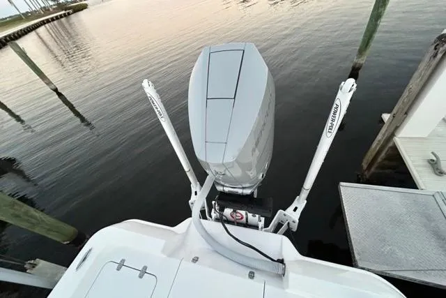 Slide: The Image of 2025 Contender 26 Bay boat with outboard motor, docked on calm water. - 10