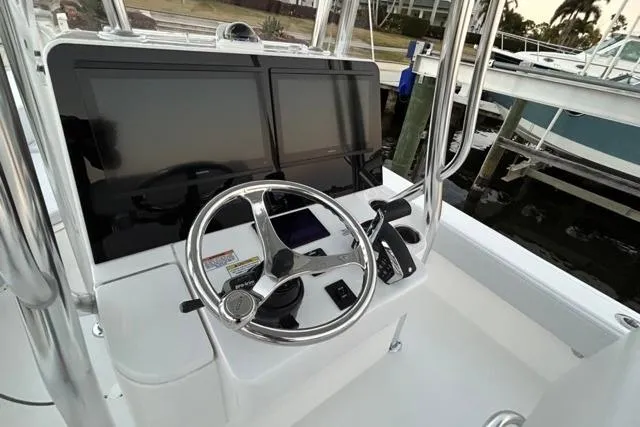 Slide: The Image of Helm of 2025 Contender 26 Bay boat with dual screens and steering wheel. - 14