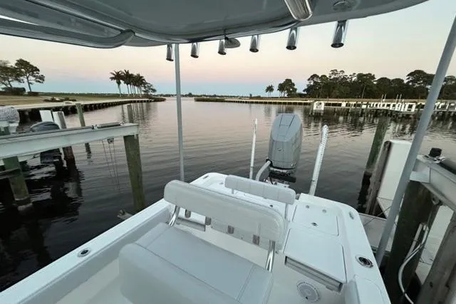 Slide: The Image of 2025 Contender 26 Bay boat docked at serene waterfront with palm trees. - 21