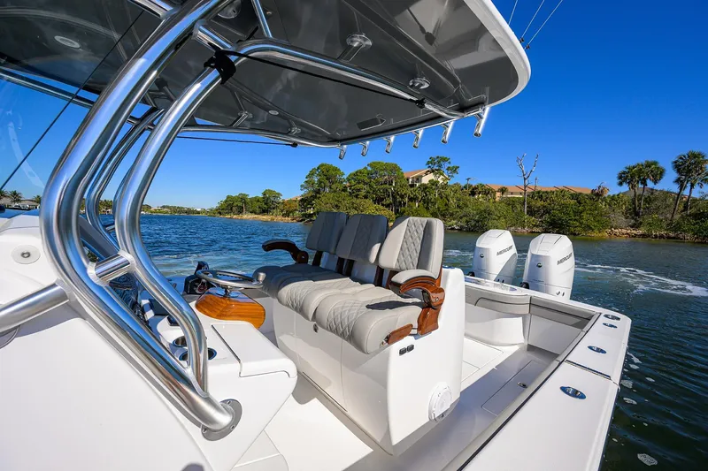 Slide: The Image of 2024 Valhalla Boatworks V-33 with luxurious seating and dual engines on a scenic waterway. - 12