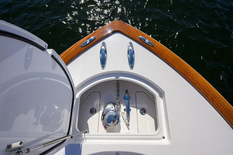 Slide: The Image of 2024 Valhalla Boatworks V-33 bow with anchor compartment, wooden trim, and ocean view. - 18