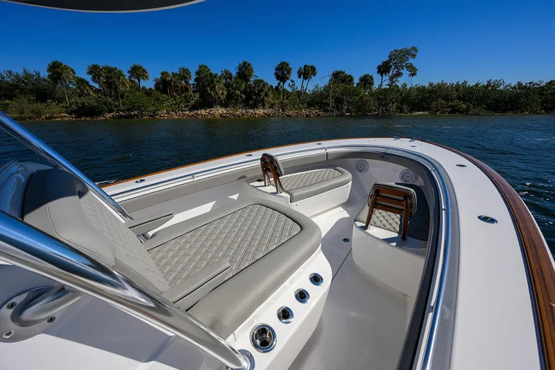 Slide: The Image of 2024 Valhalla Boatworks V-33 interior with luxurious seating, cruising on a scenic waterway. - 19
