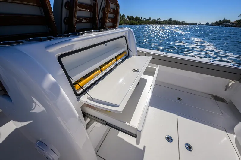 Slide: The Image of 2024 Valhalla Boatworks V-33 with open storage compartment on deck, overlooking sparkling water. - 33