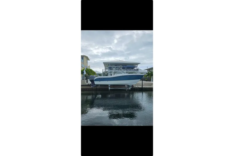 Slide: The Image of 2019 World Cat 255 DC boat docked by waterfront under cloudy sky. - 3