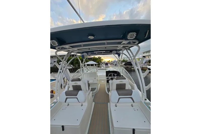 Slide: The Image of 2019 World Cat 255 DC boat interior with seating and helm, docked at sunset. - 4